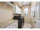 Well-organized laundry room with modern appliances, white cabinets, and ample counter space at 9524 E Caley Cir, Englewood, CO 80111