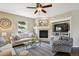 Comfortable living room featuring a fireplace, TV, and a ceiling fan at 9524 E Caley Cir, Englewood, CO 80111