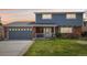 Traditional home featuring a brick and siding exterior, two-car garage, and manicured front lawn at 8732 W Arbor Ave, Littleton, CO 80123
