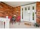 Inviting front porch with brick accents, outdoor seating, and a decorative 'hello' welcome mat at 8732 W Arbor Ave, Littleton, CO 80123