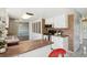 Well-lit kitchen with updated appliances, brick backsplash, and a view into an adjacent room at 8732 W Arbor Ave, Littleton, CO 80123