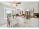 Bright kitchen with white cabinets, an island, and adjacent dining area with large windows at 8732 W Arbor Ave, Littleton, CO 80123