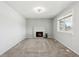 Inviting living room with a cozy fireplace, plush carpeting, and a bright window for ample natural light at 8732 W Arbor Ave, Littleton, CO 80123