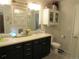 Bathroom featuring double sinks, dark cabinetry, and a classic design at 6850 E Archer Dr, Denver, CO 80230
