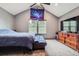 Bedroom with a ceiling fan, vaulted ceilings, dresser and view of outdoor foliage at 9672 W Chatfield Ave # C, Littleton, CO 80128