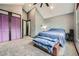 Spacious bedroom with vaulted ceiling, neutral walls, plush carpet, and purple closet doors at 9672 W Chatfield Ave # C, Littleton, CO 80128