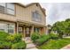 Two-story townhouse with brick facade, trimmed windows, manicured shrubs, and front lawn at 9672 W Chatfield Ave # C, Littleton, CO 80128