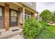Inviting front entrance with brick facade, covered entry, and lush, green landscaping at 9672 W Chatfield Ave # C, Littleton, CO 80128