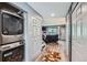 Hallway featuring a washer and dryer, closet, and view into a living room at 9672 W Chatfield Ave # C, Littleton, CO 80128