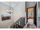 Hallway view with chandelier fixture and a view into the bedroom with the arched window at 9672 W Chatfield Ave # C, Littleton, CO 80128