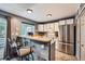 Updated kitchen with stainless steel appliances, breakfast bar, and white cabinetry at 9672 W Chatfield Ave # C, Littleton, CO 80128