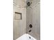 Modern tiled shower and bath with built-in shelving and modern fixtures at 1213 Jamaica St, Aurora, CO 80010