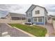 A fenced backyard with a grassy lawn, a small patio with outdoor seating, and rock landscaping at 4444 N Picadilly Ct, Aurora, CO 80019