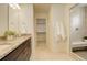 Bright bathroom featuring a walk-in shower, granite counters, dual vanity, and soft tile flooring at 4444 N Picadilly Ct, Aurora, CO 80019
