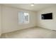 Empty bedroom with a window, soft carpet, neutral walls, and a ceiling light fixture at 4444 N Picadilly Ct, Aurora, CO 80019