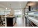 Stylish kitchen featuring stainless steel appliances, dark cabinetry, and an island with seating overlooking the backyard at 4444 N Picadilly Ct, Aurora, CO 80019