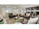 Comfortable living room featuring large windows for natural light and seamless flow to the modern kitchen at 4444 N Picadilly Ct, Aurora, CO 80019