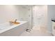 Bathroom features a soaking tub with textured tile, frameless glass shower, and wood-look tile floors at 2826 Broadway St # 106, Boulder, CO 80304