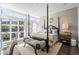 Bright main bedroom with large windows, a four-poster bed, and an inviting sitting area at 2826 Broadway St # 106, Boulder, CO 80304