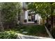 Beautiful backyard featuring lush greenery, a stone patio, and easy access to the home's interior at 8774 Martin Luther King Blvd, Denver, CO 80238