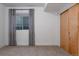 Neutral toned bedroom with soft carpet, large closet, and window with gray and white tree-patterned curtains at 8774 Martin Luther King Blvd, Denver, CO 80238