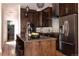 Modern kitchen with dark wood cabinets, stainless steel appliances, and a stylish island with seating at 8774 Martin Luther King Blvd, Denver, CO 80238