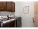 Modern laundry room boasts sleek dark washer and dryer units and modern white walls at 8774 Martin Luther King Blvd, Denver, CO 80238