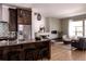 Open-concept kitchen and living room features stainless steel appliances, dark cabinetry, and hardwood floors at 8774 Martin Luther King Blvd, Denver, CO 80238