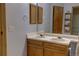 Bathroom featuring double sink, wooden cabinet and wall mounted storage at 9771 W Cornell Pl, Lakewood, CO 80227