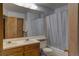 Bathroom with double sink, full mirror, and combination shower and tub at 9771 W Cornell Pl, Lakewood, CO 80227