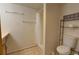 Bathroom featuring white vanity, shower with curtain, toilet, and metal shelving at 9771 W Cornell Pl, Lakewood, CO 80227