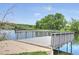 Picturesque dock extending into a serene lake surrounded by lush greenery and blue skies at 9771 W Cornell Pl, Lakewood, CO 80227