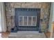 Close up of the stone fireplace featuring a gas insert and tools at 9771 W Cornell Pl, Lakewood, CO 80227