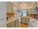 Well-lit kitchen with stainless steel dishwasher and view to living room and staircase at 9771 W Cornell Pl, Lakewood, CO 80227