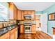 Well-lit kitchen featuring stainless steel appliances, granite countertops, and light brown wooden cabinets at 30633 Kings Valley Dr, Conifer, CO 80433