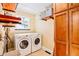 Bright laundry room featuring a modern washer and dryer, custom shelving, and a window at 30633 Kings Valley Dr, Conifer, CO 80433