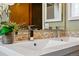 Bright bathroom featuring double sinks with modern faucet fixtures and a mosaic backsplash at 1001 E 17Th Ave # 12, Denver, CO 80218