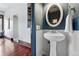 Stylish powder room with pedestal sink, white wainscoting, and an elegant oval mirror at 1001 E 17Th Ave # 12, Denver, CO 80218