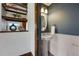 Cozy powder room with a pedestal sink, white wainscoting, and decorative mirror at 1001 E 17Th Ave # 12, Denver, CO 80218