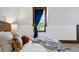 Close up of a bedroom with a window framed in stained wood and a plush decorative pillow at 1001 E 17Th Ave # 12, Denver, CO 80218