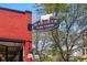 Commercial sign for Marczyk Fine Foods with a cow graphic on the sign and lights below it at 1001 E 17Th Ave # 12, Denver, CO 80218