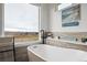 Spa-like bathroom with a soaking tub, scenic views, and sleek fixtures at 10741 Idalia Way, Commerce City, CO 80022