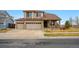 Traditional home boasting a three-car garage, covered porch, and well-maintained front lawn at 10741 Idalia Way, Commerce City, CO 80022