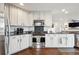 Updated kitchen featuring white cabinets, granite countertops, and stainless steel appliances at 10741 Idalia Way, Commerce City, CO 80022
