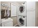 Efficient laundry room featuring a stacked washer and dryer, with built in cabinetry at 10741 Idalia Way, Commerce City, CO 80022