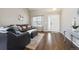 Cozy living room with dark wood floors, leather furniture, and a front door entryway at 10741 Idalia Way, Commerce City, CO 80022