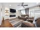 Stylish living room featuring an electric fireplace, ceiling fan, and a large area rug at 10741 Idalia Way, Commerce City, CO 80022