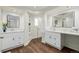 A renovated bathroom featuring dual vanities, wood flooring, and modern fixtures at 6800 S Pennsylvania St, Centennial, CO 80122