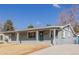 Single-story home features a welcoming front porch and a well-manicured lawn at 6800 S Pennsylvania St, Centennial, CO 80122