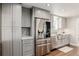 This kitchen features stainless steel refrigerator and appliances, paired with modern grey cabinetry at 6800 S Pennsylvania St, Centennial, CO 80122